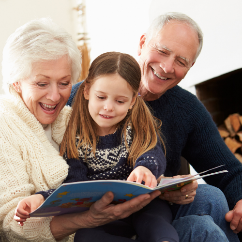 Grandparents reading a book with their grandchild